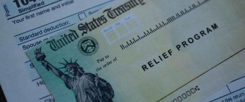 Form 1040 U.S. Individual Income tax return next to the Stimulus Check Relief program. Close up view.