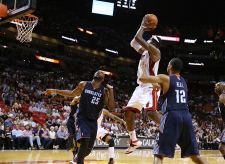 Mar 3, 2014; Miami, FL, USA; Miami Heat small forward LeBron James (6) makes a shot as Charlotte Bobcats center Al Jefferson (25) and shooting guard Gary Neal (12) look on in the second half at American Airlines Arena. The Heat won 124-107. Robert Mayer-USA TODAY Sports