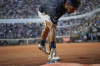 Fabio Fognini picks up his racket after throwing it to the ground during his match against Jannik Sinner at the Italian Open tennis tournament, in Rome, Wednesday, May 11, 2022. (AP Photo/Andrew Medichini)