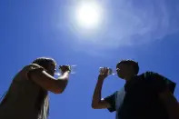 FILE - Tony Berastegui Jr., 15, right, and his sister Giselle Berastegui, 12, drink water July 17, 2023, in Phoenix. (AP Photo/Ross D. Franklin, File)