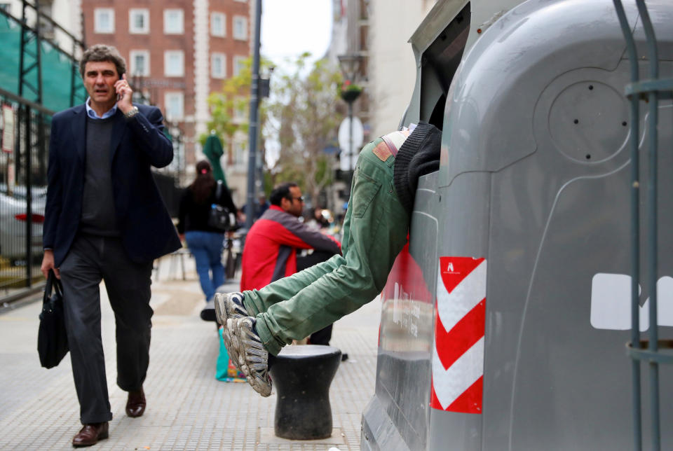 <p>Im Finanzviertel von Buenos Aires sucht ein Mann nach in einem Müllcontainer nach Verwertbarem. (Bild: Reuters/Marcos Brindicci) </p>