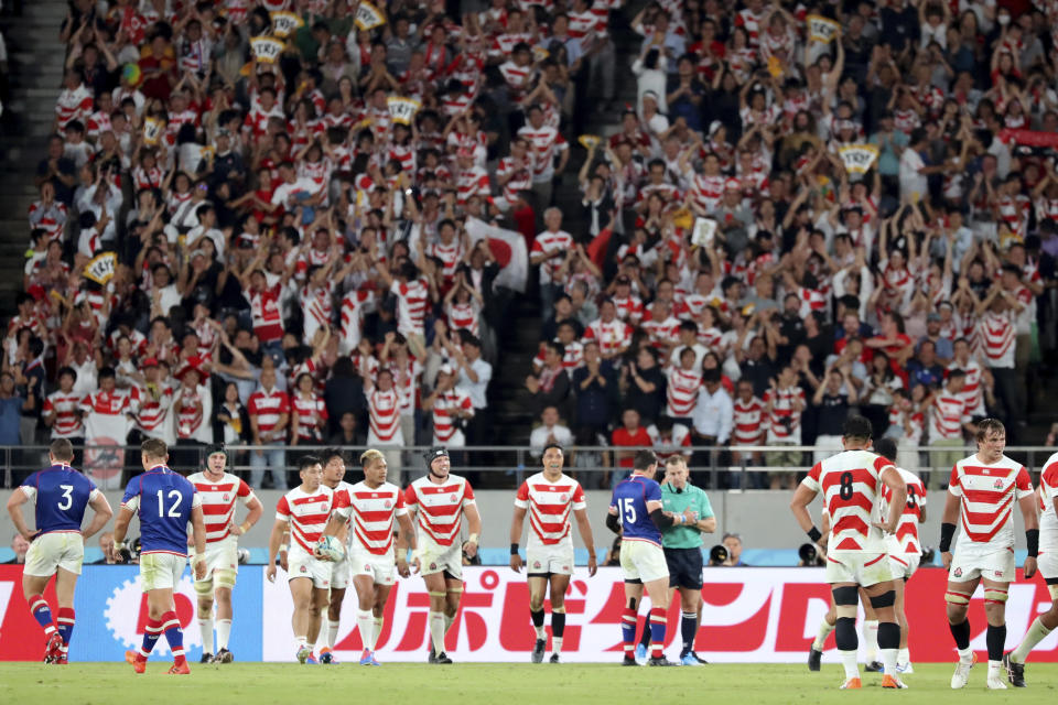 Japan team's members react after Pieter Labuschagne, wearing black headguard at center, scored a try during the Rugby World Cup Pool A game at Tokyo Stadium between Russia and Japan in Tokyo, Japan, Friday, Sept. 20, 2019. (AP Photo/Eugene Hoshiko)