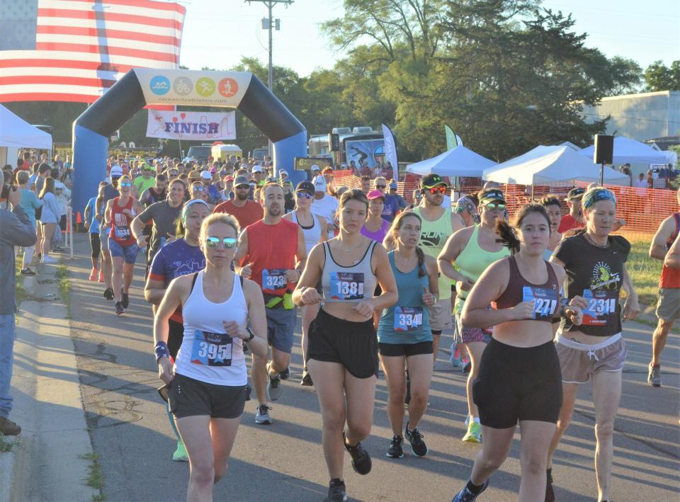 Runners take off from the starting line of the 2022 Battle Creek Half Marathon & 5K outside of the Battle Creek Field of Flight Air Show and Balloon Festival on Saturday.