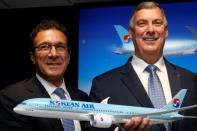 Boeing Commercial Airplanes CEO Kevin McAllister and Ihssane Mounir pose with a model of Boeing 787 Dreamliner for a commercial announcement during the 53rd International Paris Air Show at Le Bourget Airport near Paris