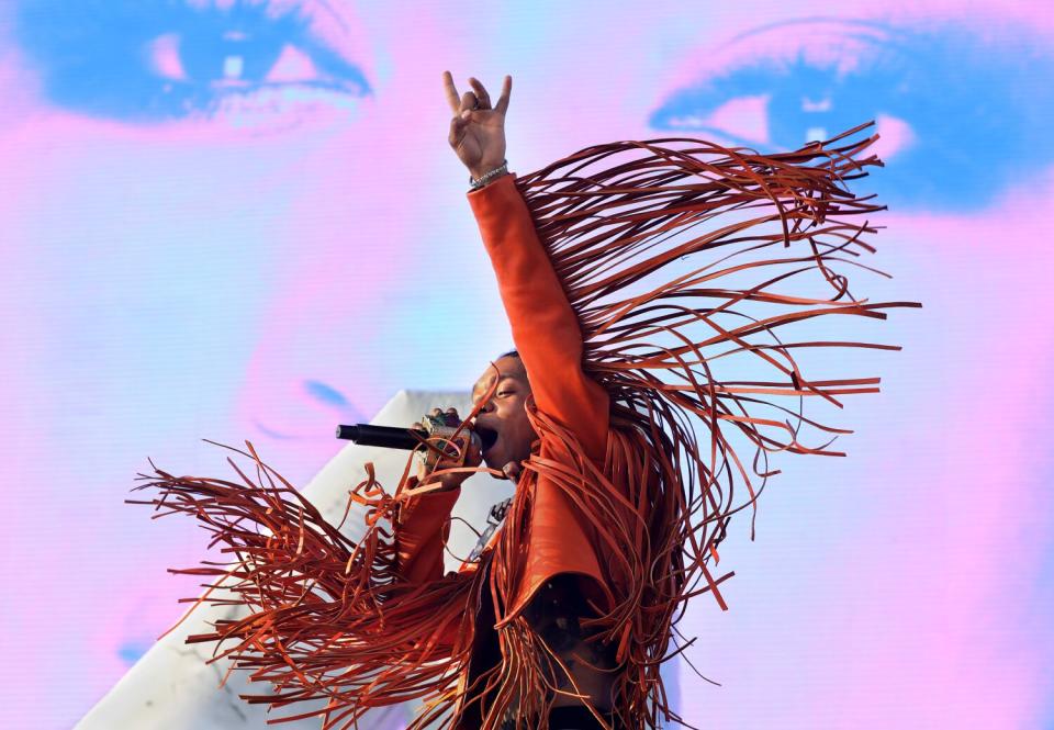 Rae Sremmurd onstage against the large pink and blue backdrop of a face