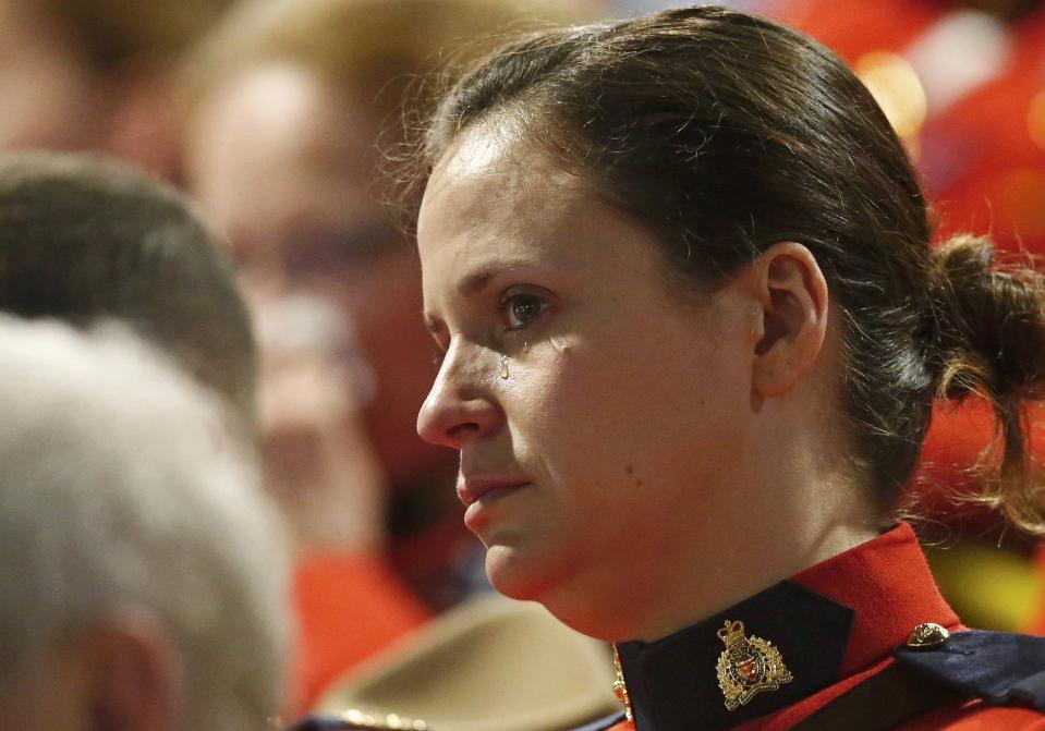 A Royal Canadian Mounted Police officer cries during a regimental funeral for three follow officers who were killed last week in Moncton