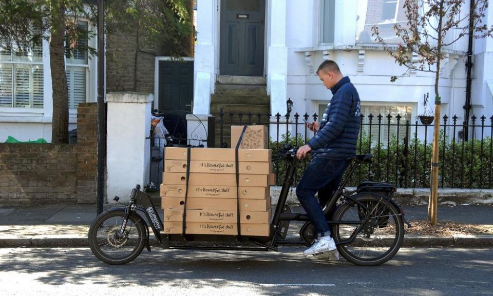 A delivery man on an electric cargo bike delivers flowers in Balham, London