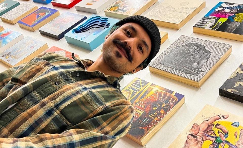 Tattoo artist and printmaker Mario Alonso Perez stands in front of his work, above his left shoulder, at the El Paso Frame Co. “The One with All the Squares 2” exhibit, up through Dec. 23.