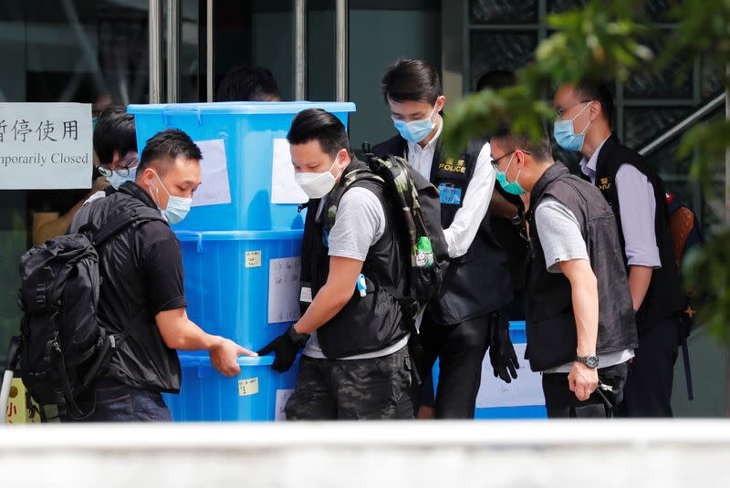 Police officers collect evidence from the headquarters of Apple Daily and Next Media after media mogul Jimmy Lai Chee-ying, founder of Apple Daily was detained by the national security unit in Hong Kong
