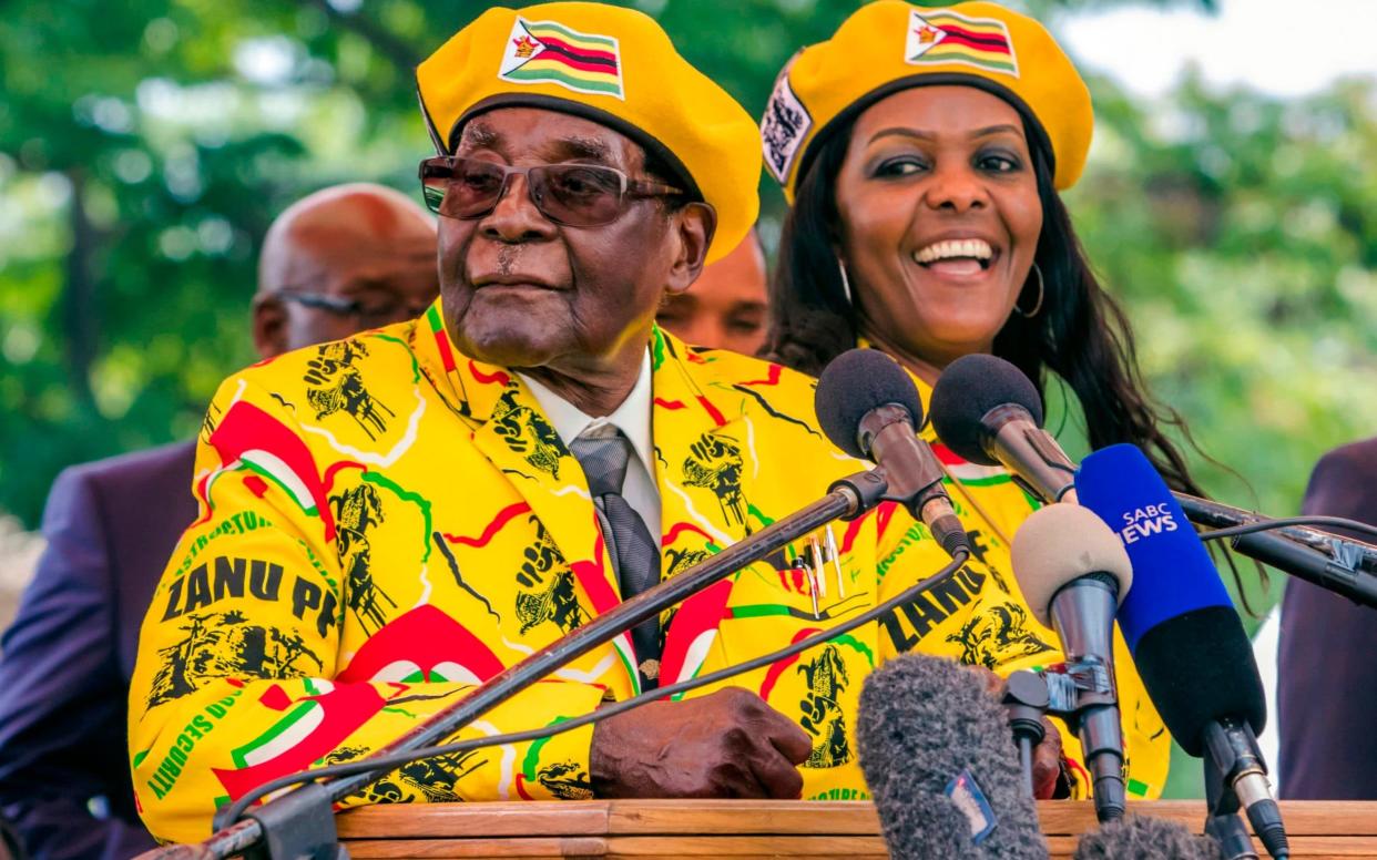 Mr Mugabe speaks at his party headquarters to show support to Grace Mugabe, right, becoming the party's next vice president - AFP