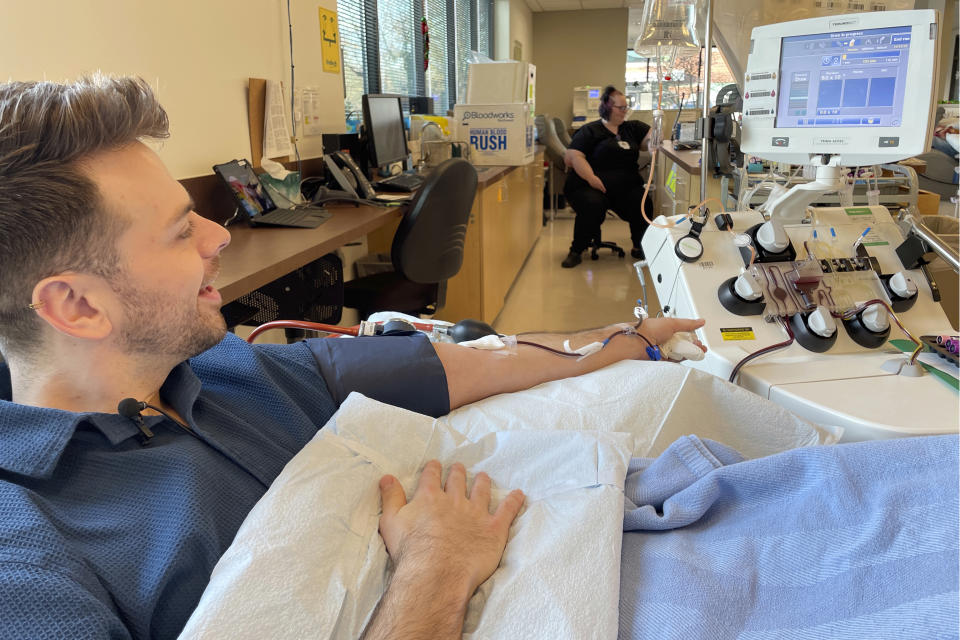 Dylan Smith donates blood platelets at Bloodworks Northwest, where he works as a donor services supervisor, Friday, Dec. 15, 2023, in Vancouver, Wash. More gay and bisexual men can now donate blood in the U.S., and many in Washington state are doing so. (AP Photo/Claire Rush)