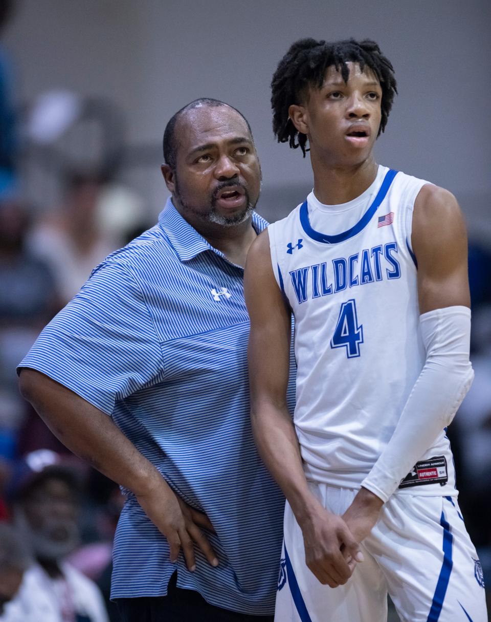 Wildcats head coach Dwayne Louis talks with Bryant Fields Jr. (4) during a break in action during the Tate vs Washington boys basketball game at Booker T. Washington High School in Pensacola on Thursday, Dec. 9, 2021.  The Wildcats ultimately defeated the Aggies 70-54.