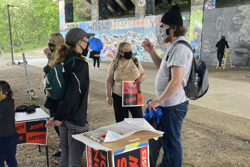 Activist Jan Rivers, left, talks with residents walking along the Atlanta Beltline about progressive movement priorities during an organizing event on April 10, 2021, in Atlanta. Rivers is part of a wide-ranging coalition of progressive organizations trying to pressure Congress on a long list of legislative proposals favored by the left. But the movement faces roadblocks in the evenly divided Senate. (AP Photo/Bill Barrow)