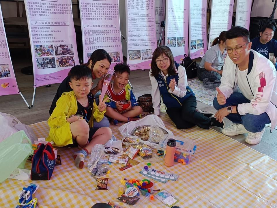 家長帶著孩子在野餐區享受美味的異國點心。圖：婦幼局提供