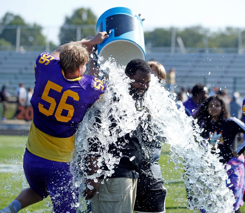 South Bend Clay senior Jeremy Cleveland (56) and another unidentified person dump a water cooler on Colonials football head coach Darius Mitchell following the team's 54-0 win against North Newton Saturday, Sept. 30, 2023, at Clay Middle School in South Bend.