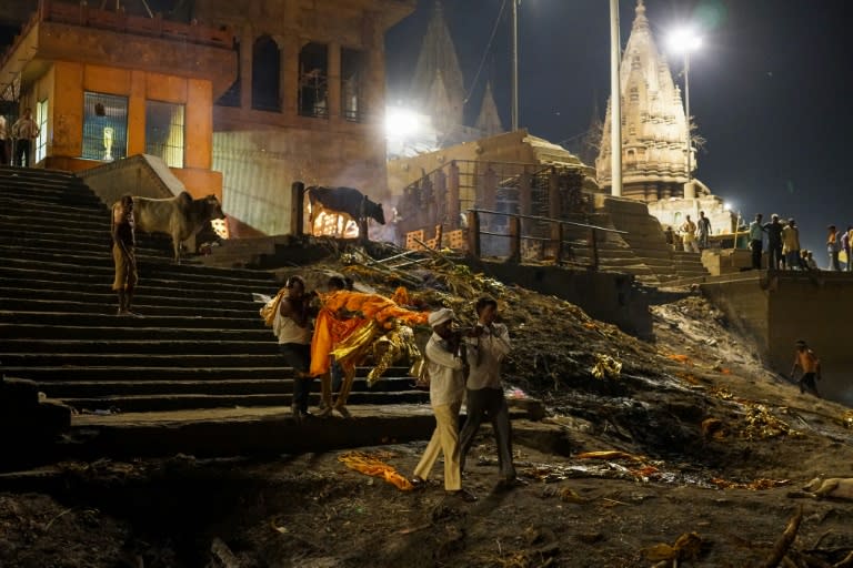 Indian men carry a dead body for cremation at the Manikarnika ghat in the old quarters of Varanasi