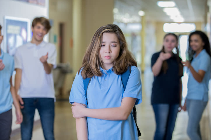 a young girl looking embarrassed in the hallway at school