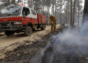 A firefighter patrols a controlled fire as they work at building a containment line at a wildfire near Bodalla, Australia, Sunday, Jan. 12, 2020. Authorities are using relatively benign conditions forecast in southeast Australia for a week or more to consolidate containment lines around scores of fires that are likely to burn for weeks without heavy rainfall. (AP Photo/Rick Rycroft)