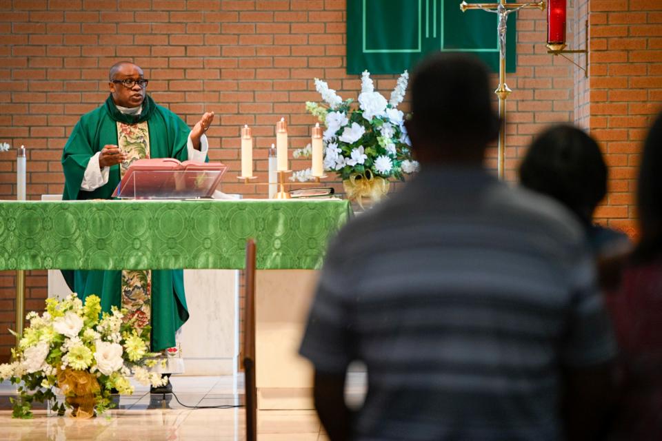 Parishioners stand in Our Lady of Grace Catholic Church in Reserve, La., during a sermon by the Rev. Fr. Christopher Chike Amadi.