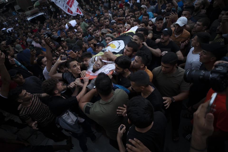 Palestinian mourners carry the bodies of victims killed earlier in an Israeli airstrike, during their funeral in Gaza City, Friday, Aug. 5, 2022. Palestinian officials say Israeli airstrikes on Gaza have killed several people, including a senior militant, and wounded 40 others. (AP Photo/Fatima Shbair)