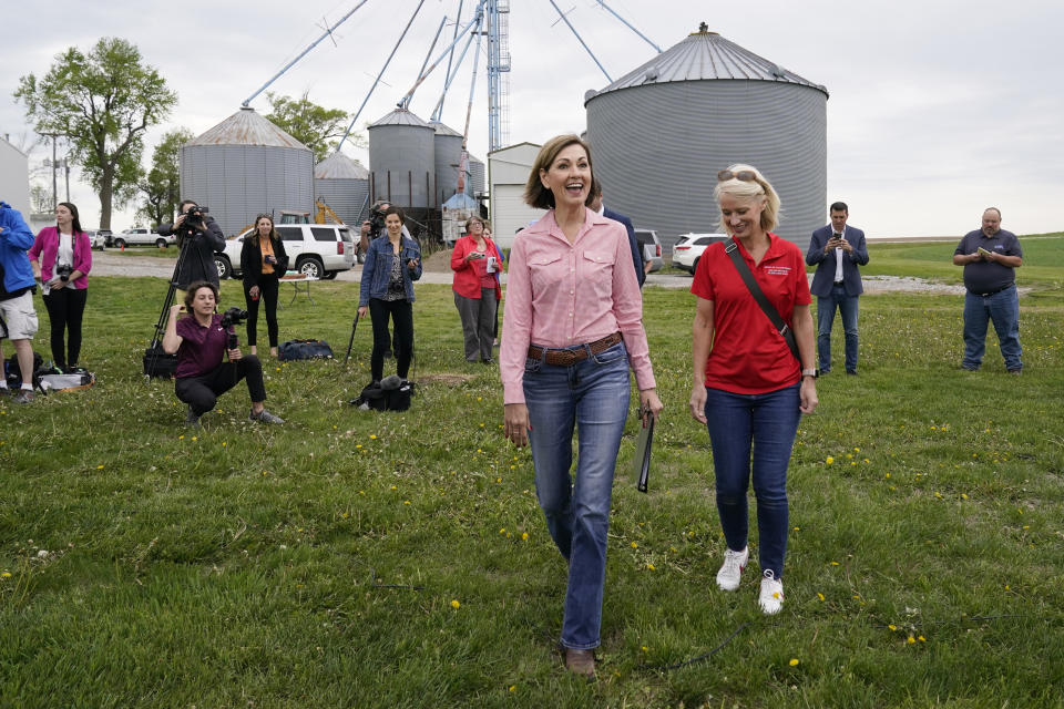 Iowa Gov. Kim Reynolds, center, arrives to sign the Biofuels Bill, Tuesday, May 17, 2022, in Prairie City, Iowa. (AP Photo/Charlie Neibergall)