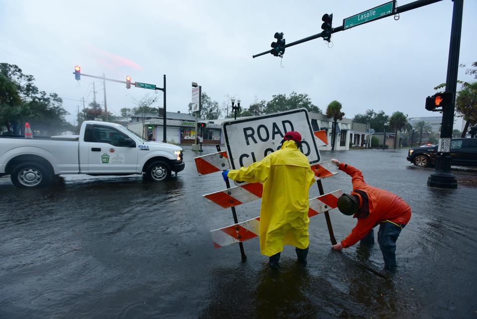 Crews from the Jacksonville Public Works department put up a road closed sign after they were blown down under Nicole's winds on Thursday.