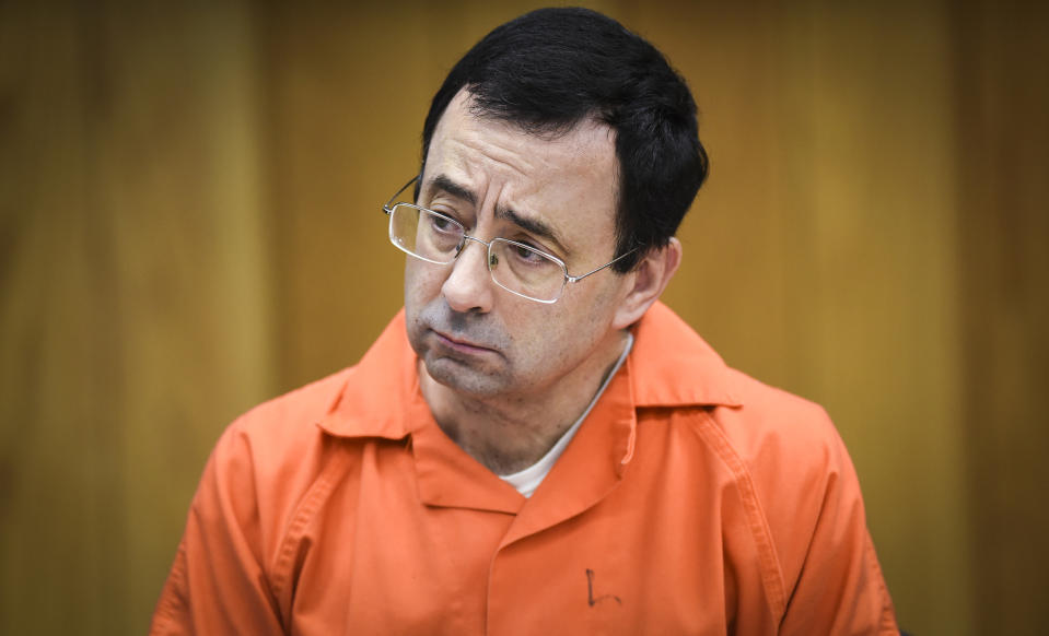 FILE - In this Feb. 2, 2018, file photo, Larry Nassar listens as Melissa Alexander Vigogne gives her victim statement in Eaton County Circuit Court in Charlotte, Mich. The U.S. Olympic Committee has fired chief of sport performance Alan Ashley in the wake of an independent report that said neither he nor former CEO Scott Blackmun elevated concerns about the Larry Nassar sexual abuse allegations when they were first reported to them. The 233-page independent report was released Monday, Dec. 10, 2018. It detailed an overall lack of response when the USOC leaders first heard about the Nassar allegations from the then-president of USA Gymnastics, Steve Penny. Blackmun resigned in February because of health concerns.(Matthew Dae Smith/Lansing State Journal via AP, File)