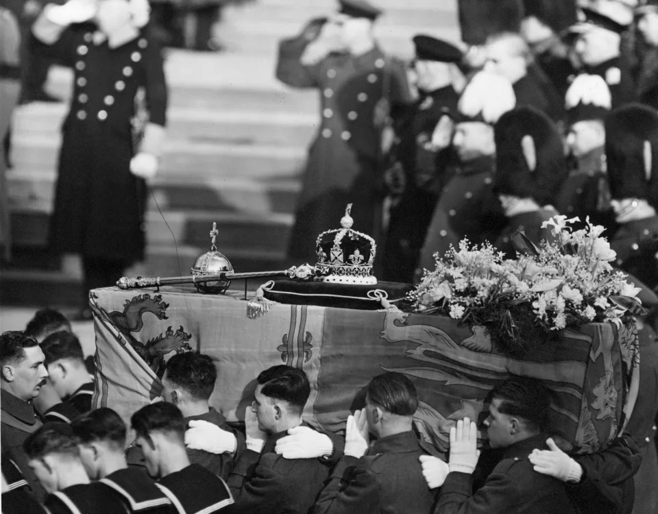 15th February 1952:  The coffin of George VI  draped with the royal standard being carried by soldiers. On the top are symbols of royalty, a crown, sceptre and orb.  (Photo by George W. Hales/Fox Photos/Getty Images)