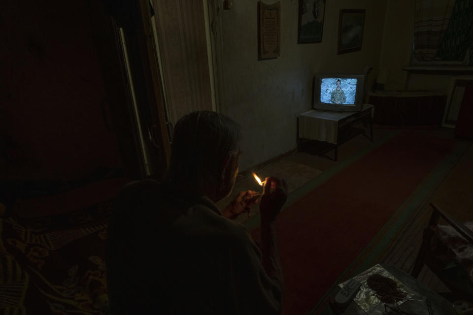 Seventy-year-old pensioner Valerii Ilchenko, who lives alone and is refusing to evacuate, watches television in his apartment, in Kramatorsk, eastern Ukraine, Wednesday, July 6, 2022. Now a widower, Ilchenko says he still has no intention of leaving. "I don't have anywhere to go and don't want to either. What would I do there? Here at least I can sit on the bench, I can watch TV," he says in an interview in his single-room apartment. (AP Photo/Nariman El-Mofty)