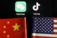 FILE PHOTO: Illustration picture of Wechat and TikTok apps near China and U.S. flags