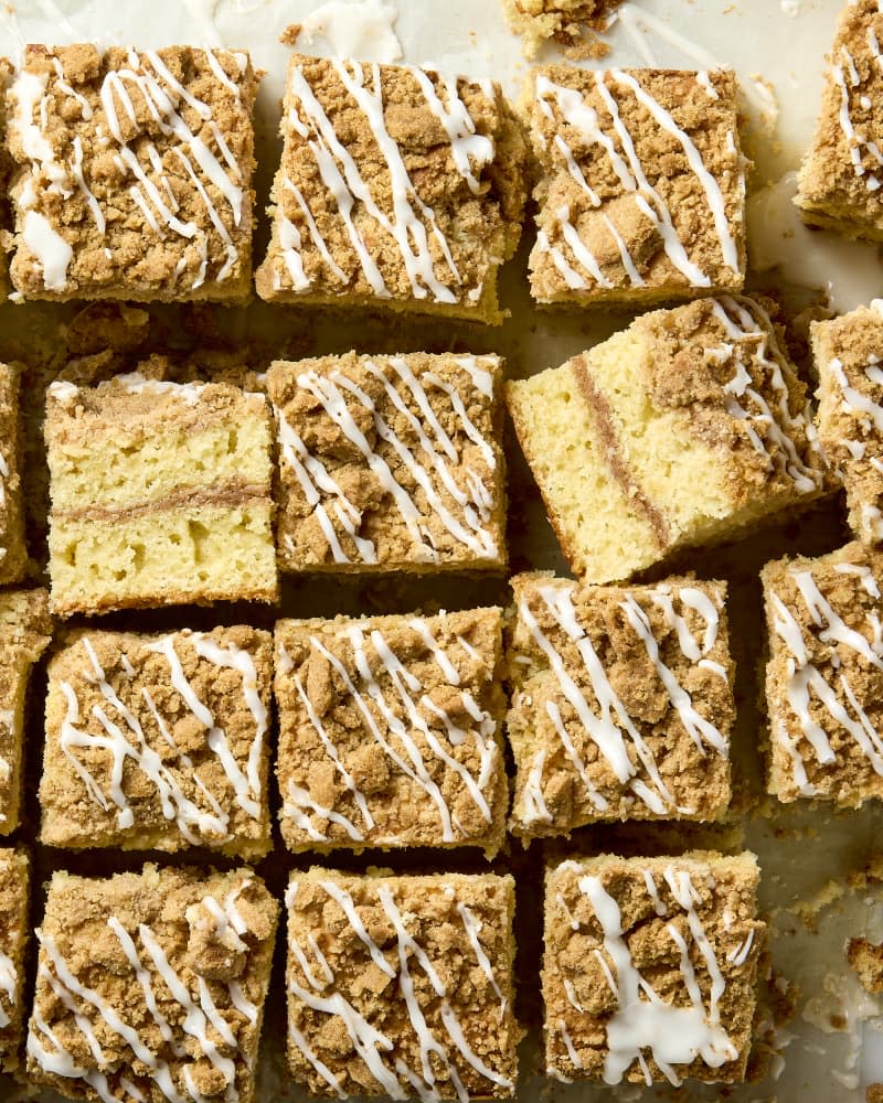 overhead shot of a full pan of coffee cake, with a piece in the middle turned up a bit facing the camera to show the layers.