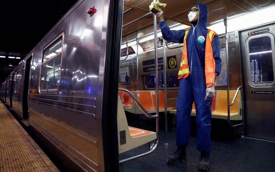 A worker wipes down surfaces as the MTA Subway closed overnight for cleaning and disinfecting during the outbreak of coronavirus (COVID-19) in the Brooklyn borough of New York City - Andrew Kelly/Reuters