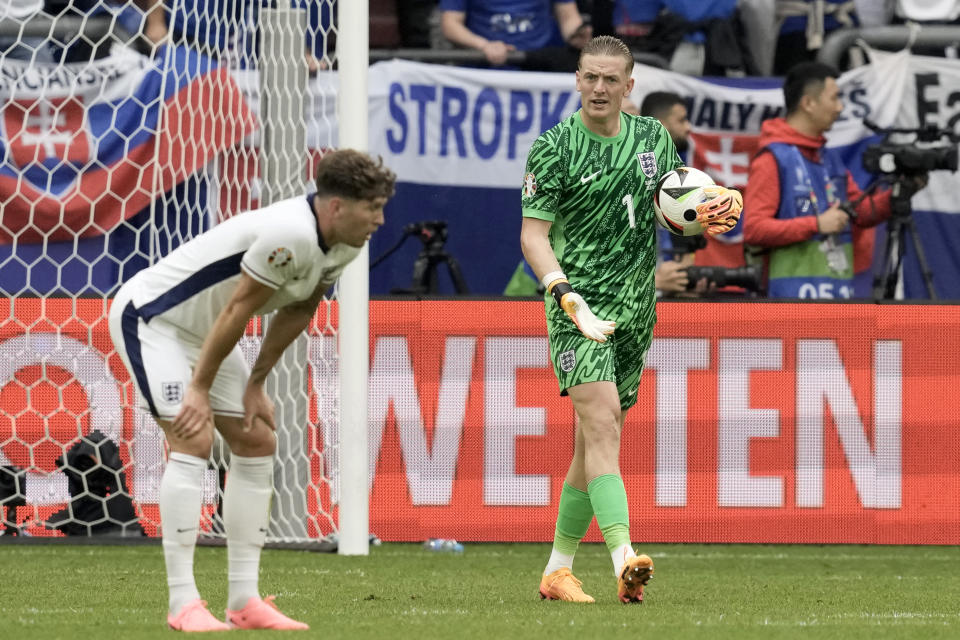 England's goalkeeper Jordan Pickford and John Stones, left, react after Slovakia's Ivan Schranz scored the opening goal during a round of sixteen match between England and Slovakia at the Euro 2024 soccer tournament in Gelsenkirchen, Germany, Sunday, June 30, 2024. (AP Photo/Thanassis Stavrakis)