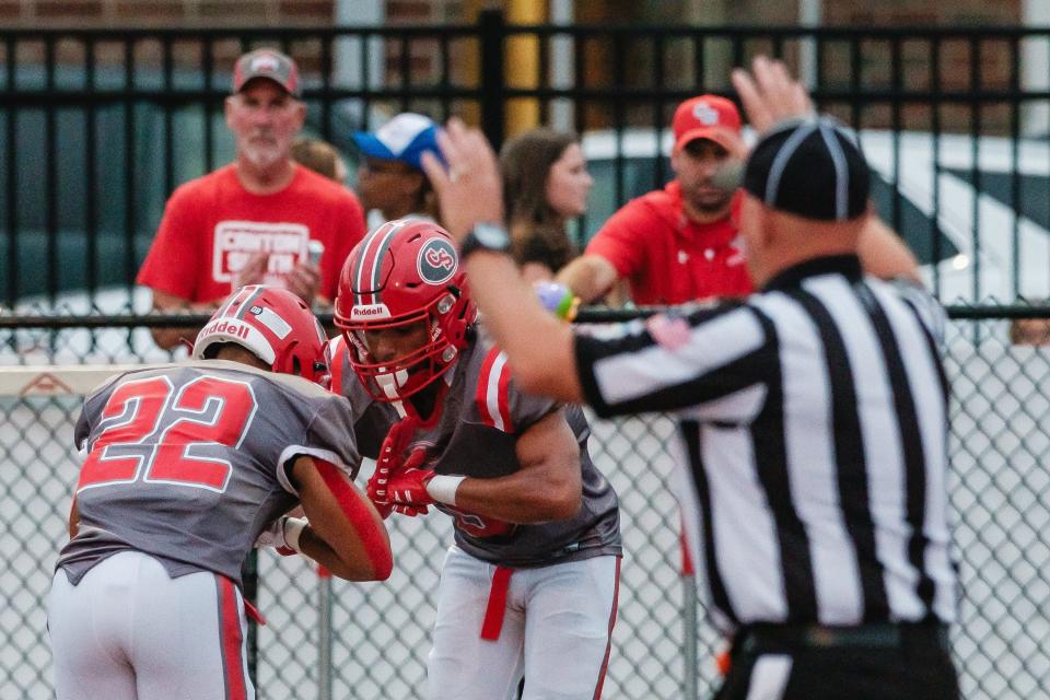 Canton South's Tre Wilson, left, and Tavon Castle, middle, celebrate a touchdown catch by Castle against Dover, Friday, Aug. 25, 2023.