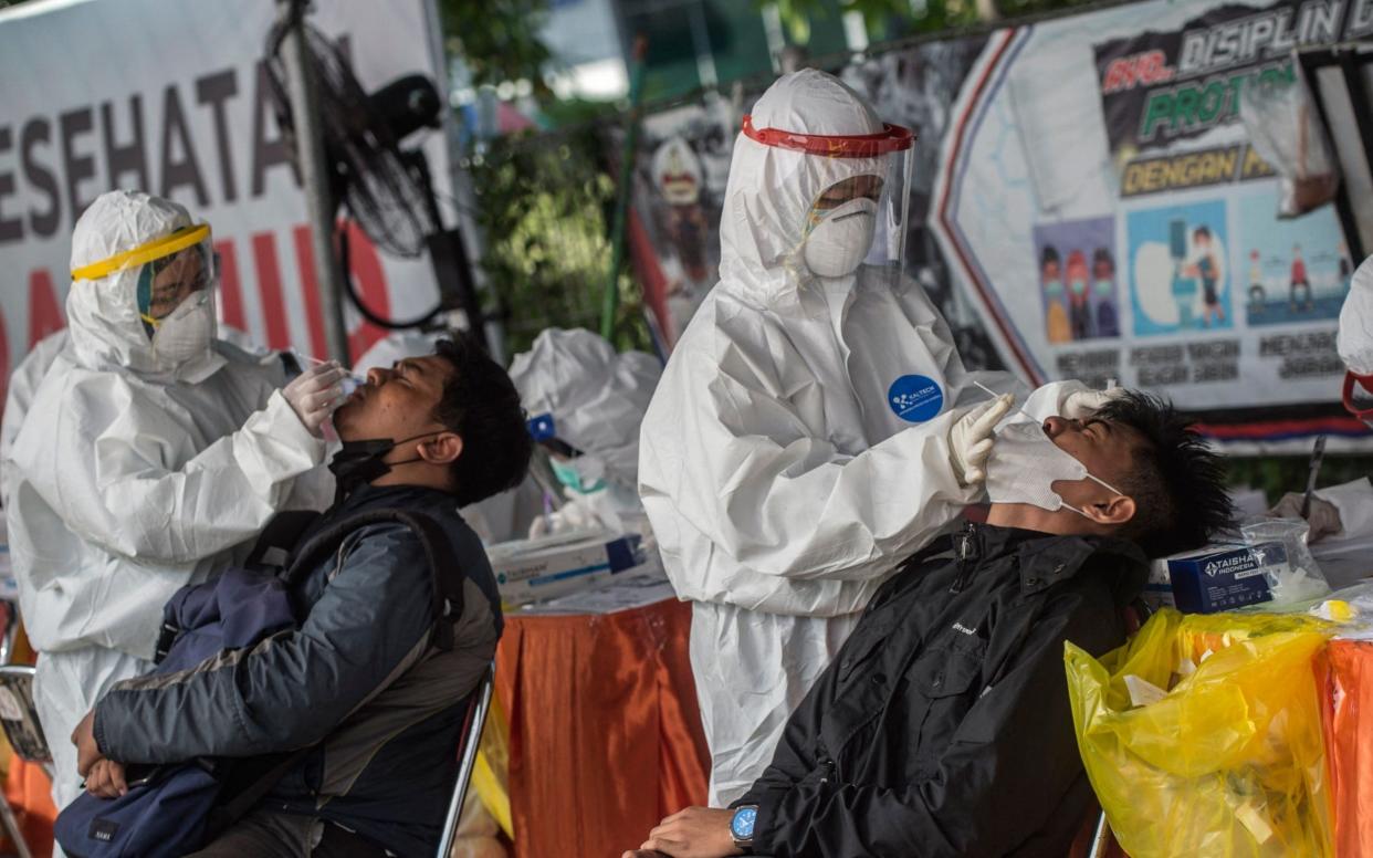 Passengers and motorists from Madura island get swab tests for Covid-19 coronavirus before entering the Surabaya area at a checkpoint on June 10, 2021