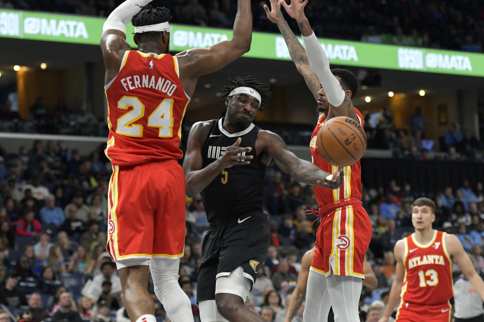Memphis Grizzlies guard Vince Williams Jr. (5) is defended by Atlanta Hawks forward Bruno Fernando (24) and guard Dejounte Murray during the second half of an NBA basketball game Friday, March 8, 2024, in Memphis, Tenn. (AP Photo/Brandon Dill)