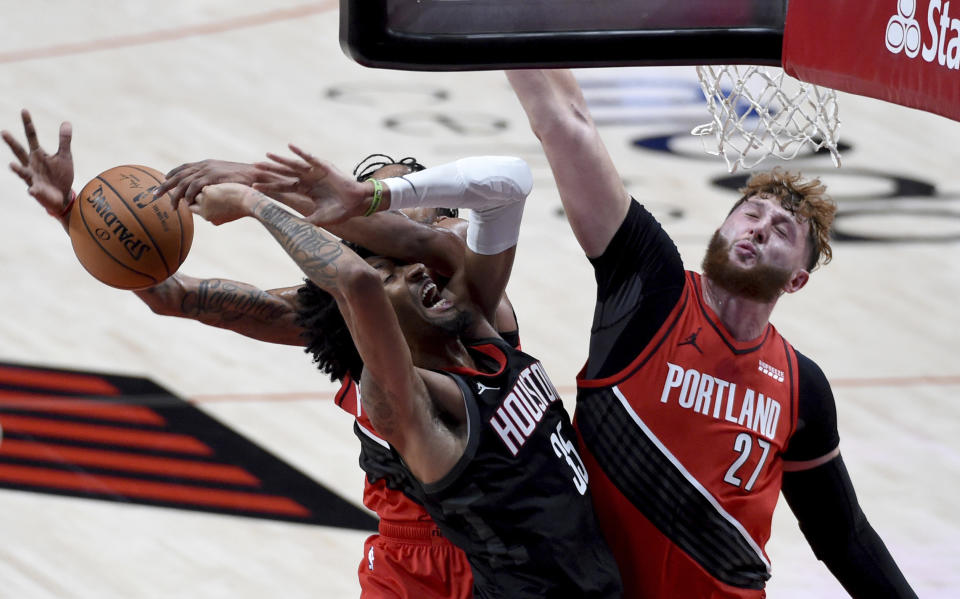 Houston Rockets forward Christian Wood, left, drives to the basket on Portland Trail Blazers center Jusuf Nurkic, right, during the first half of an NBA basketball game in Portland, Ore., Saturday, Dec. 26, 2020. (AP Photo/Steve Dykes)