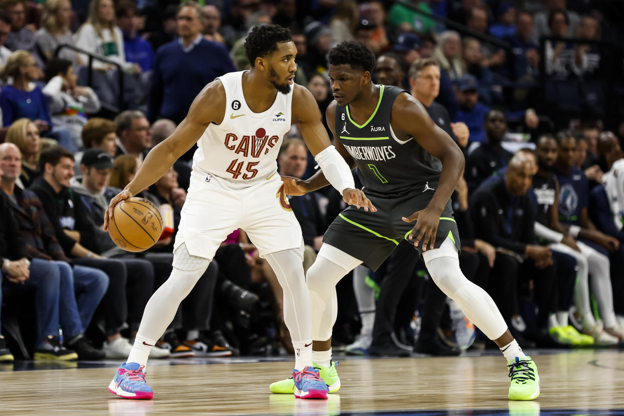 Donovan Mitchell #45 of the Cleveland Cavaliers dribbles the ball while Anthony Edwards #1 of the Minnesota Timberwolves defends