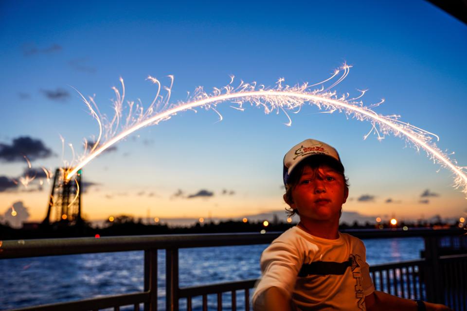 Dylan Truesdell, 9, of Palm City, plays with a sparkler during the City of Stuart's “Red, White and Blue in Uniform” Fourth of July Celebration on Monday, July 4, 2022, in downtown Stuart. The event celebrated our nations independence and honored the courage and commitment of our first responders and featured live music and a fireworks display over the St. Lucie River. 