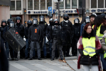 French police secure a street near a bank as protesters wearing a yellow vest attend a demonstration by the "yellow vests" movement in Paris, France, December 8, 2018. REUTERS/Benoit Tessier