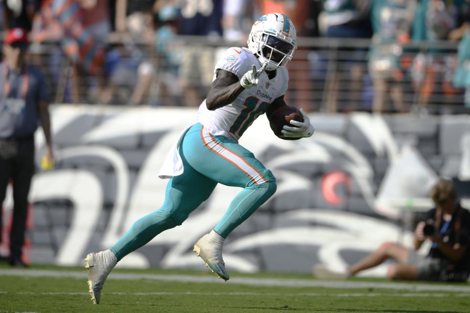 Dolphins receiver Tyreek Hill gestures as he runs for a touchdown after catching a pass from Tua Tagovailoa during Sunday's win in Baltimore.