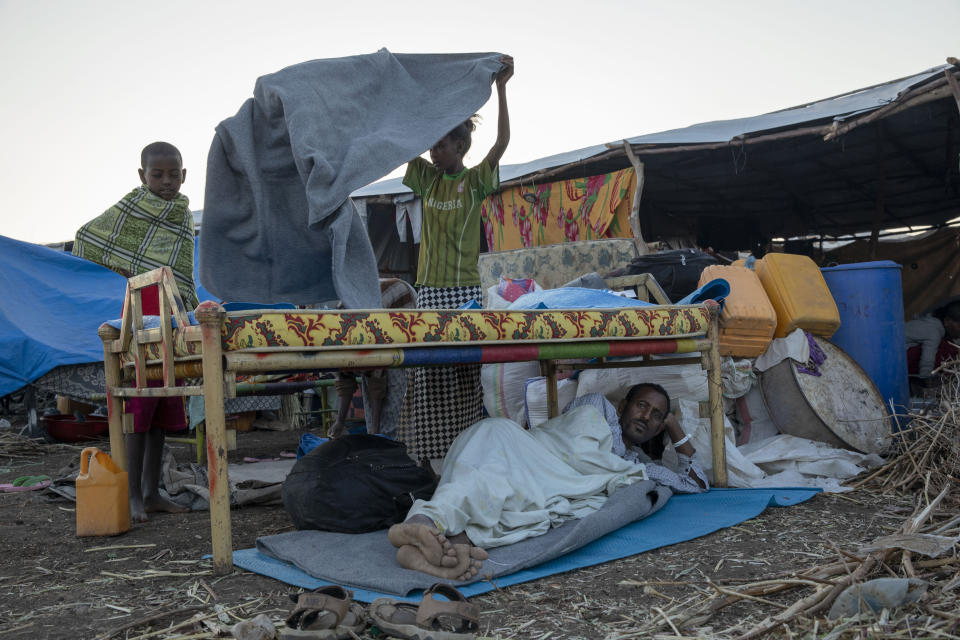 Tigray refugees who fled the conflict in the Ethiopia's Tigray wake up at Hamdeyat Transition Center near the Sudan-Ethiopia border, eastern Sudan, Thursday, Dec. 3, 2020. Ethiopian forces on Thursday blocked people from the country's embattled Tigray region from crossing into Sudan at the busiest crossing point for refugees, Sudanese forces said.(AP Photo/Nariman El-Mofty)