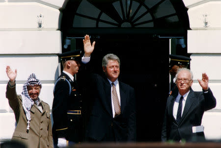 FILE PHOTO: PLO Chairman Yasser Arafat (L) waves with Israeli Prime Minister Yitzhak Rabin (R) and U.S. President Bill Clinton after the signing of the Israeli-PLO peace accord, at the White House in Washington, U.S., September 13, 1993. REUTERS/Gary Hershorn/File Photo