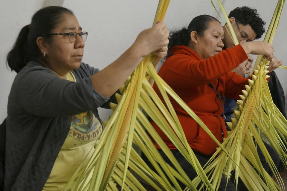 From left, Isabel Tenorio, Elizabeth Ramirez and her son, Victor, weave palm fronds into elaborate designs at the Church of the Incarnation in Minneapolis on Wednesday, March 29, 2023. Tenorio started the workshops to maintain alive the faith tradition from her native Mexico and to raise funds for the Catholic church, where the palms will be sold, and blessed, at Palm Sunday services this weekend. (AP Photo/Giovanna Dell’Orto)