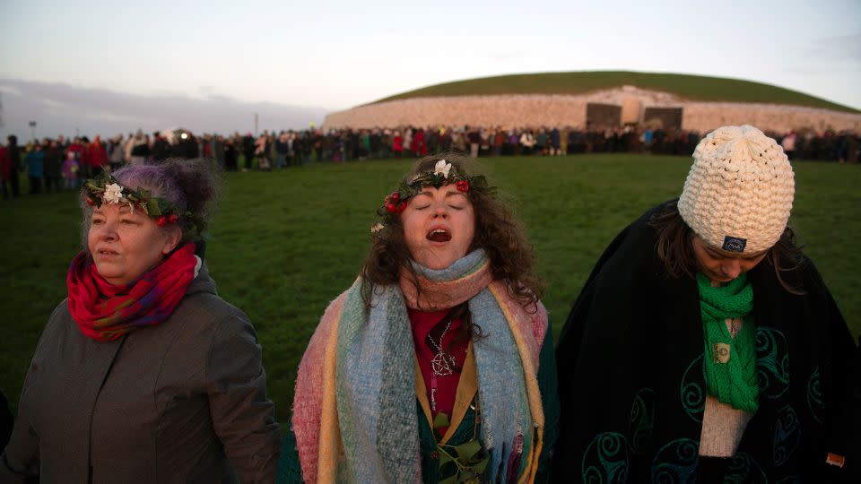 A woman chants as people gather in a circle to witness the winter solstice on December 21, 2022, in Newgrange, Ireland. - Charles McQuillan/Getty Images
