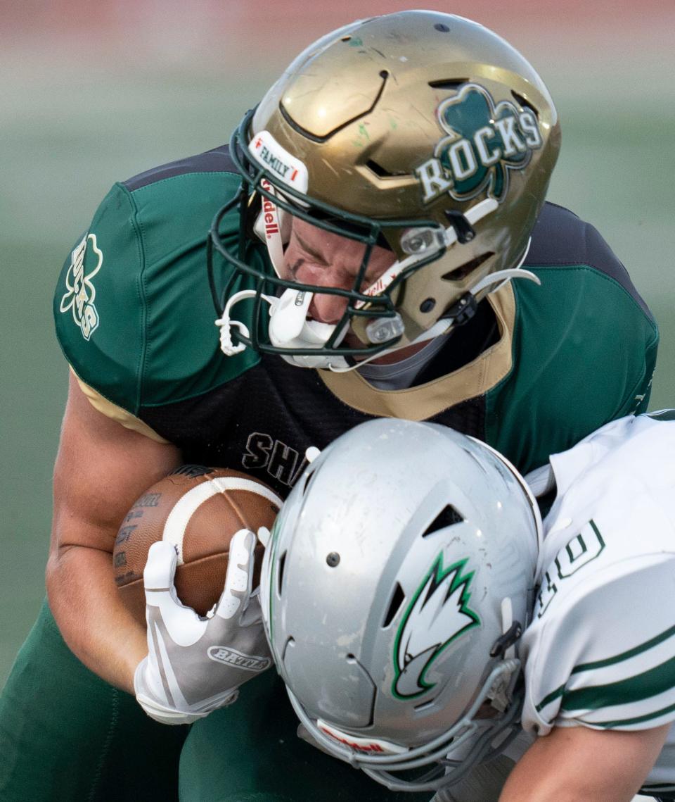 Westfield’s Mikeah Webster, back, is tackled by Zionsville’s Luke Murphy, front, on Friday, Sept. 2, 2022, at Riverview Health Stadium in Westfield. Westfield won 23-16.