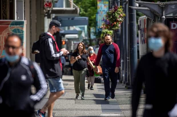 People are pictured walking along Granville Street in downtown Vancouver, British Columbia. (Ben Nelms/CBC - image credit)