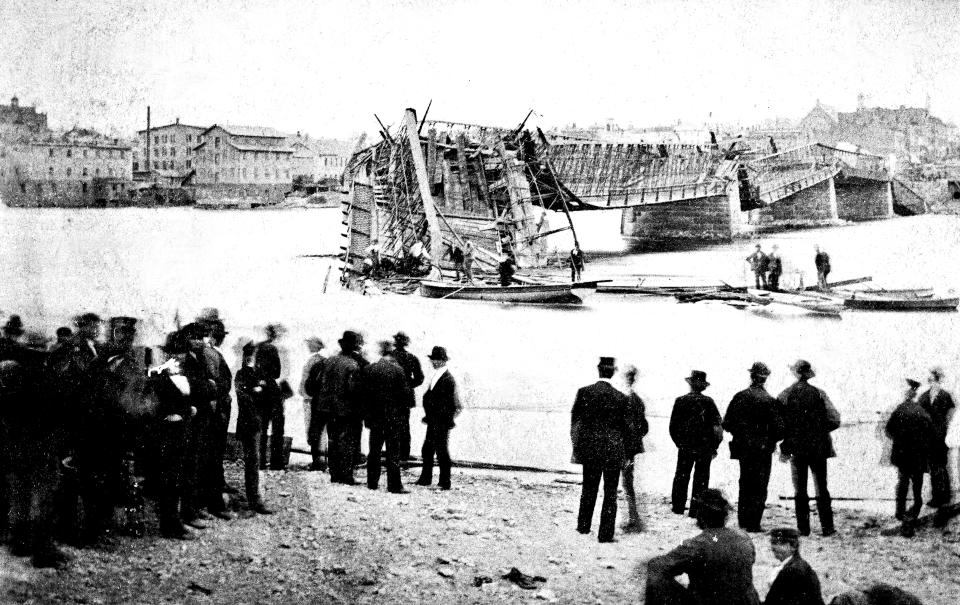 In this photo provided by Lee County Historical and Genealogical Society, people gather near the Truesdell Bridge in Dixon, Ill., following its collapse in 1873. It's been 150 years since the bridge collapsed, remaining the worst road-bridge disaster in American history. On May 4, 1873, a crowd of more than 200 gathered on the bridge to watch a baptism when it toppled over, trapping dozens of victims just inches below the river's surface. The disaster claimed 46 lives and injured dozens of others. (Charles Keyes/Lee County Historical and Genealogical Society via AP)