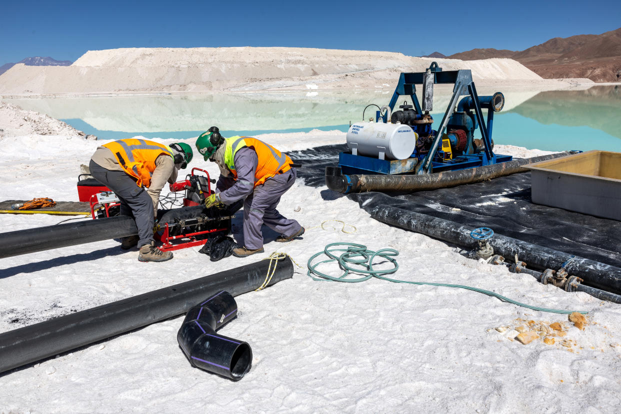 SALAR DE ATACAMA, CHILE - AUGUST 24: Lithium mine workers inspect machinery at an evaporation pond in the Atacama Desert on August 24, 2022 in Salar de Atacama, Chile. Albemarle Corporation, based in Charlotte, N.C. is expanding mining operations at their Salar Plant to meet the rising global demand for lithium carbonate, a main component in the manufacture of batteries, increasingly for electric vehicles. To extract the lithium, natural brine is pumped from under the salt flats to a series of evaporation ponds. During an 18-month process, the liquid is concentrated through a series of 15 ponds, eventually turning from blue to yellow with a lithium concentration of 6 percent. It is then trucked to an Albemarle chemical plant in Antofagasta, where it is processed into battery grade lithium carbonate powder and shipped out internationally. The evaporation process produces large quantities of salt byproduct, much of which is then reprocessed and sold. Chile is the second largest global producer of lithium, after Australia. (Photo by John Moore/Getty Images)