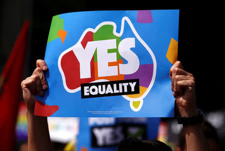 A marcher holds aloft a sign as they participates in a marriage equality march in central Sydney, Australia, October 21, 2017. REUTERS/David Gray